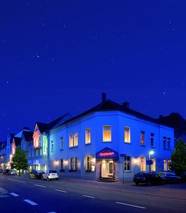 a blue building on the side of a street at night at Hotel Klute in Osnabrück