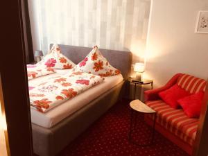 Zimmer mit einem Bett und einem Sofa mit Kissen in der Unterkunft Gästehaus Albers in Cochem