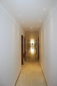 an empty hallway with white walls and a long corridor at Hotel Monterrey in Barranquilla