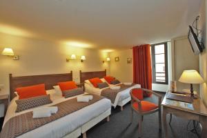 a hotel room with two beds and a desk at Hôtel Le Madrigal in Sarlat-la-Canéda