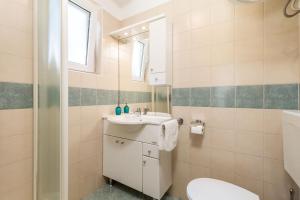 a bathroom with a sink and a toilet at Apartment in pinewood near the sea in Nerezine