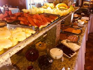 um buffet com muitos tipos diferentes de comida em uma mesa em Pousada Recanto dos Sonhos em Campos do Jordão