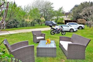 um quintal com cadeiras, uma mesa e uma moto em Hôtel Le Madrigal em Sarlat-la-Canéda