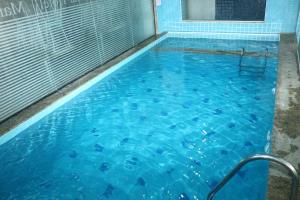 a swimming pool with blue water at Mar Hotel in Balneário Camboriú