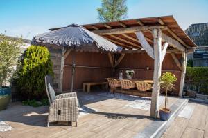 a wooden patio with a table and an umbrella at Het Ankertje (Oosterhaven) in Medemblik +26 photos