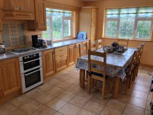 a kitchen with a table and a table and chairs at Tilly's Cottage in Durrus