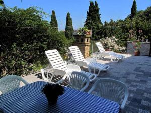 een groep witte stoelen en een tafel met een blauwe tafel bij VILLA VALKANE PET FRIENDLY 150m FROM THE STUNNING VALKANE BEACH, City indoor pools-fitness and City mall in Pula