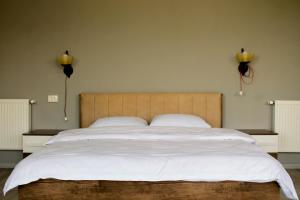 1 dormitorio con 1 cama grande con sábanas blancas en Lia's Guest House en Sighnaghi