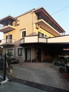 a large yellow building with balconies and a courtyard at Eftihia Studios in Kavos
