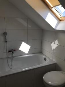 a bathroom with a tub and a toilet and a window at Wohnen am Wanderweg in Aurich +26 photos