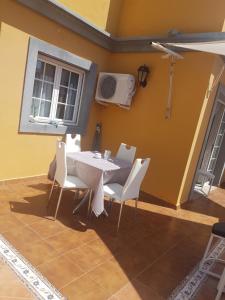 a dining room with a white table and chairs at la CASITA DEL CORAZON in Castillo del Romeral