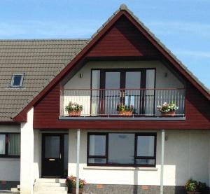 a house with potted plants on a balcony at Bosta 12 Knock in Stornoway