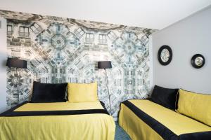 1 dormitorio con 2 camas y un mural en la pared en Mercure Paris Roissy CDG, en Roissy-en-France