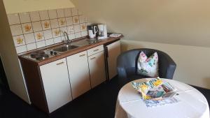 Una pequeña cocina con una mesa y un fregadero. en Hausnordlicht Dachspitze, en Dornumergrode