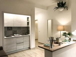 a kitchen with white cabinets and a table with a lamp at VIATOREM Suites in Torre dell'Orso