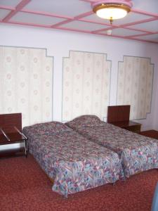 een slaapkamer met een bed, een tafel en een plafond bij Hotel Manhattan in Brussel
