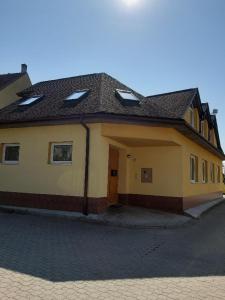 a large yellow house with a door on a street at Útulný apartmán in Veselí nad Moravou