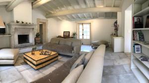 a living room with a couch and a fireplace at LE CAFE & LA FORGE du PETIT BADON in Salin-de-Giraud