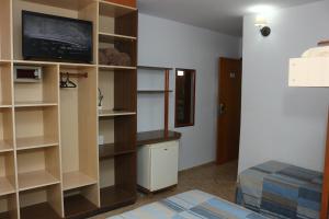 uma sala de estar com televisão e prateleiras em Mar Hotel em Balneário Camboriú