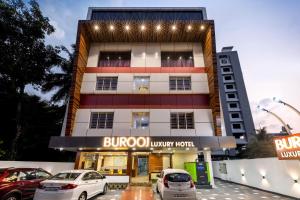 a building with cars parked in front of it at Burooj Hotel in Cochin