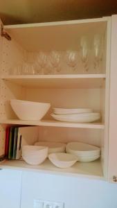 a cabinet filled with plates and bowls and dishes at Naglio apartamentai Elija in Šventoji