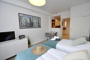 a hotel room with two beds and a television at 9 Rue Buttura in Cannes