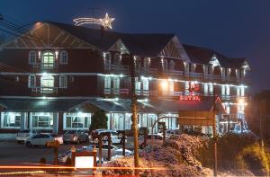 um edifício com uma estrela em cima à noite em Hotel Galo Vermelho em Gramado