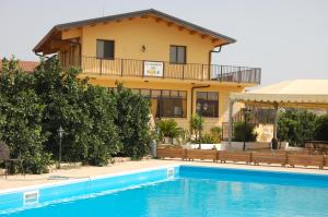 a house with a swimming pool in front of it at Il Giardino Del Sole in Agnone Bagni