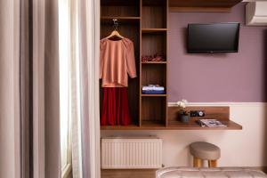 Cette chambre comprend une étagère avec une chemise et une télévision. dans l'établissement Hôtel de la Tour Eiffel, à Paris