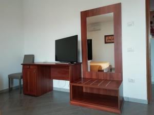 Zimmer mit einem Schreibtisch, einem TV und einem Spiegel in der Unterkunft B&B Tequila in Olbia