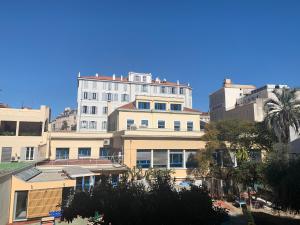 a tall white building in the middle of a city at 9 Rue Buttura in Cannes