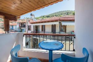 a balcony with a blue table and chairs at Mario's house in Kallirakhi