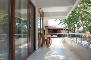 a balcony with glass doors and a table and chairs at Alpaylar Apart Hotel in Akcay