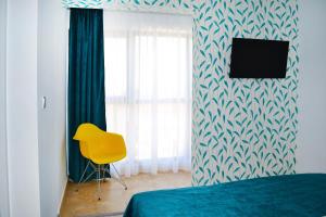 a bedroom with a bed and a yellow chair at LUCA Apartments in Saturn
