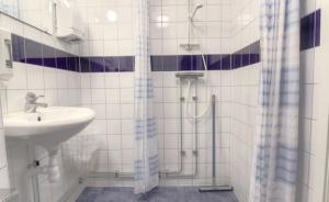 y baño blanco con lavabo y ducha. en Masthuggsterrassens Hostel, en Gotemburgo
