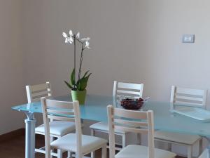 a blue table with white chairs and a plant on it at La casa di Giò in Montesilvano