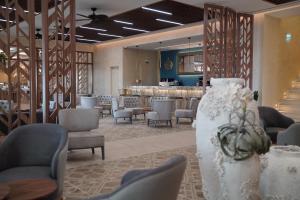 a lobby with chairs and a bar in the background at Almyros Beach in Acharavi