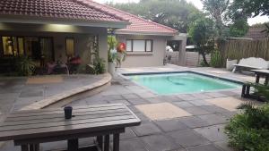 a house with a swimming pool in a yard at Magisha Guesthouse in Nelspruit