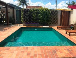 uma piscina com uma mesa e um banco num quintal em Nai'a Suites em Ubatuba
