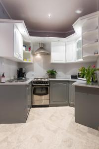 kuchnia z urządzeniami ze stali nierdzewnej i białymi szafkami w obiekcie JM Apartments zamieszkaj w Centrum w Krakowie