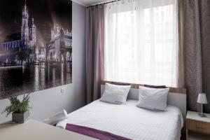 sypialnia z łóżkiem z obrazem na ścianie w obiekcie JM Apartments zamieszkaj w Centrum w Krakowie