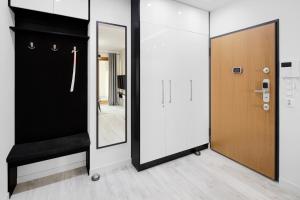 クラクフにあるNative Apartments Lubelska 10の黒い扉と鏡のある廊下