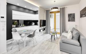 een woonkamer en een keuken met een bank en een tafel bij Native Apartments Lubelska 10 in Krakau