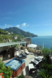 a swimming pool and lounge chairs next to the ocean at E Poi...Ravello in Ravello