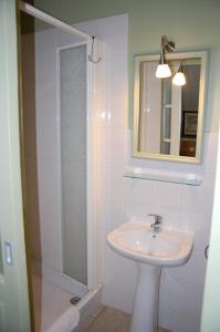 La salle de bains est pourvue d'un lavabo et d'une douche avec un miroir. dans l'établissement Clos de l'Arthonnet, à Flavignac