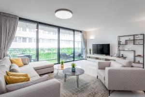 een woonkamer met witte meubels en een groot raam bij Spacious & Design 2BDR W/ balcony and parking in Tel Aviv