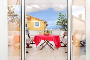 une table avec un chiffon rouge sur un balcon dans l'établissement Apartments Porto Bjelila, à Tivat