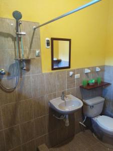 a bathroom with a sink and a toilet and a mirror at Cordillera Escalera Lodge in Tarapoto