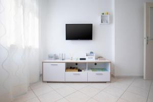 ein Wohnzimmer mit einem TV an einer weißen Wand in der Unterkunft Castropola Apartment in Pula