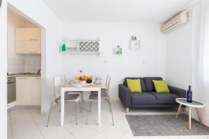 ein Wohnzimmer mit einem Tisch und einem Sofa in der Unterkunft Castropola Apartment in Pula